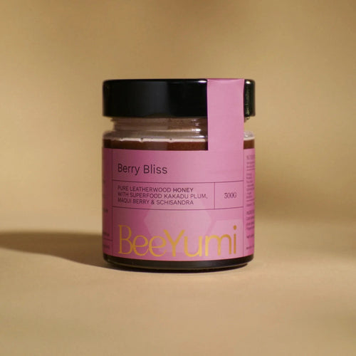 Jar of 'Berry Bliss' honey with a pink label from BeeYumi on a beige background
